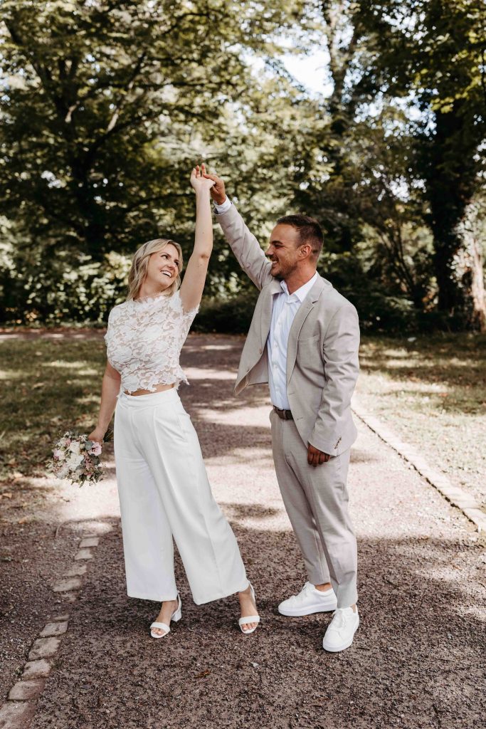 Das Brautpaar tanzt zusammen. Sie dreht sich unter seinem Arm durch. Beide strahlen