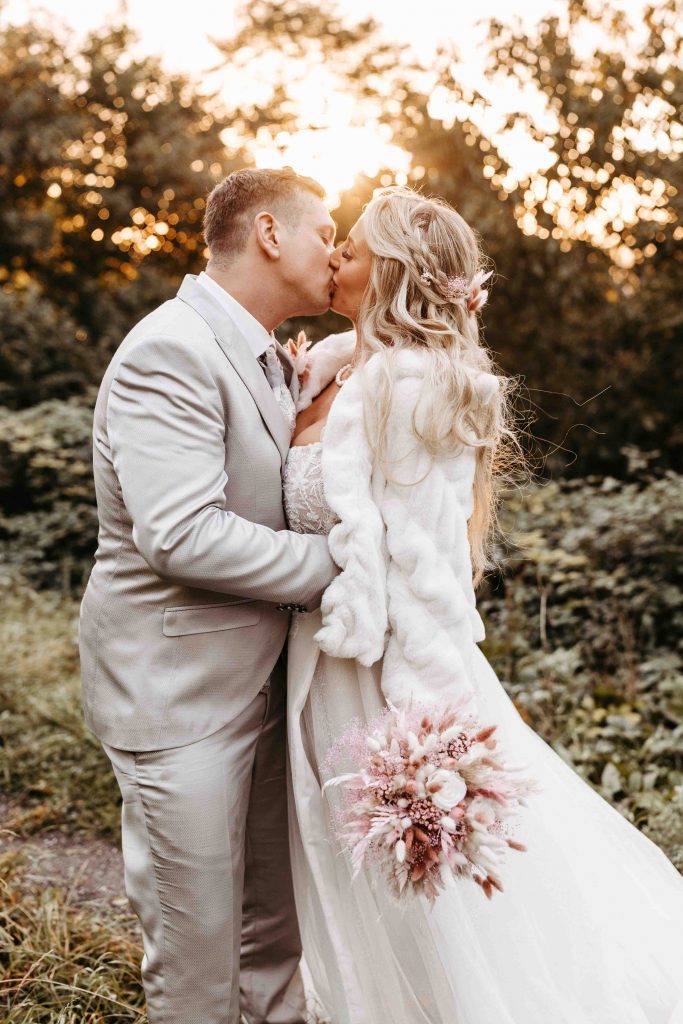 Hochzeitsfotograf Karlsruhe: Brautpaar, das sich im Sonnenuntergang küsst, sie sind eng umschlungen